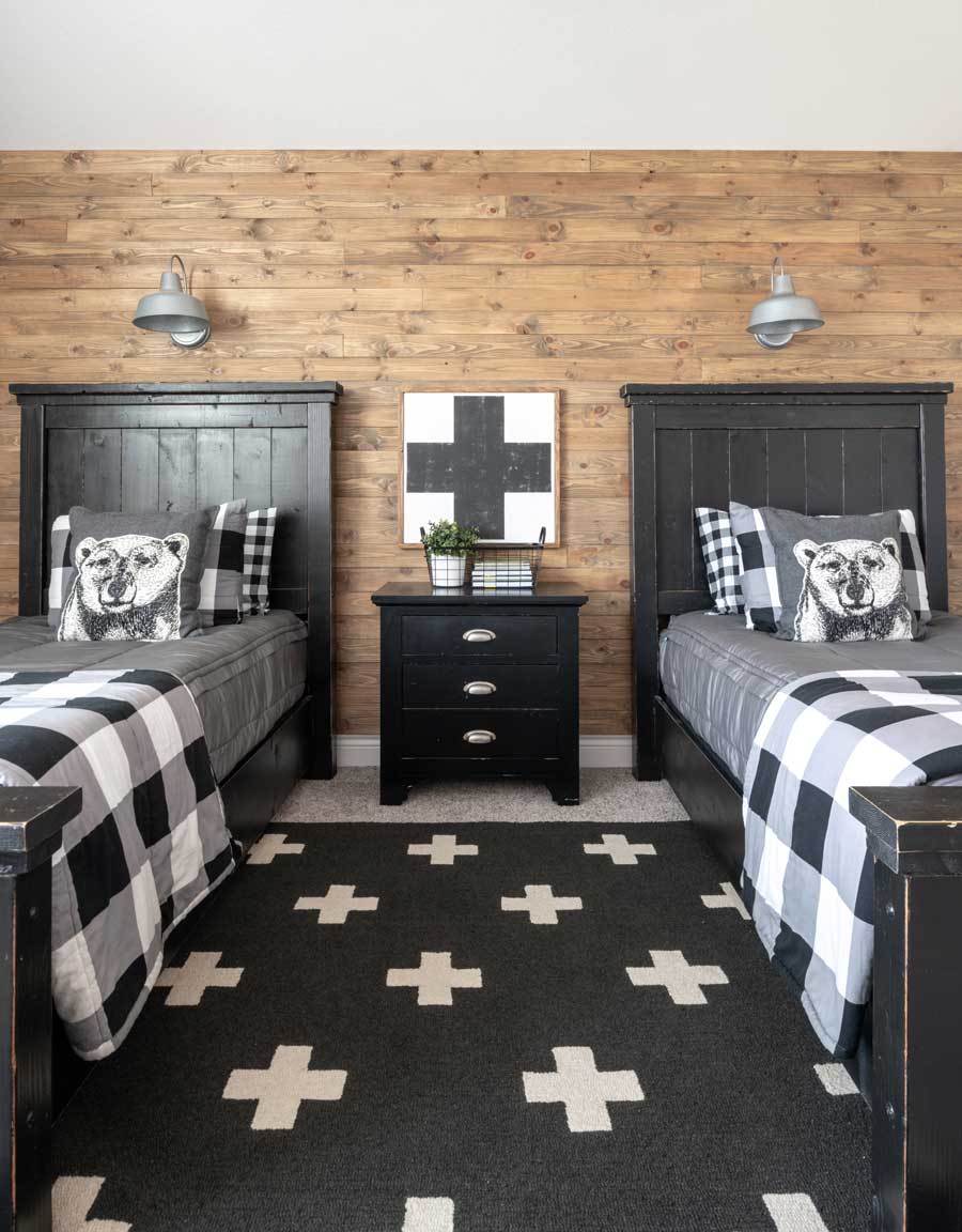 Farmhouse boys’ bedroom with DIY reclaimed wood wall and checked bedding.