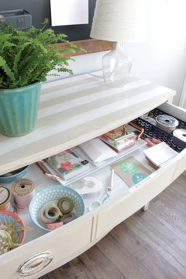 an off-white, low-level striped drawer containing gift wrap supplies