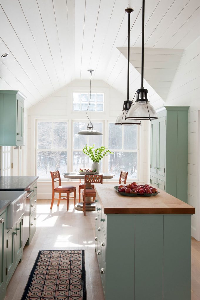 Green kitchen with shiplap walls, butcher block island and shaker cabinets