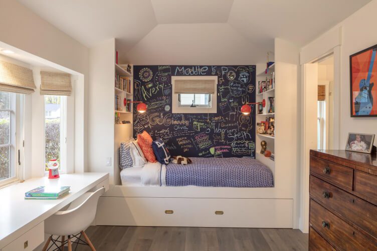 A bed with storage underneath and a functional chalkboard wall. 