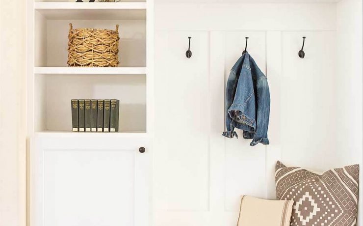 Mudroom with family name sign art, seating bench and lockers.