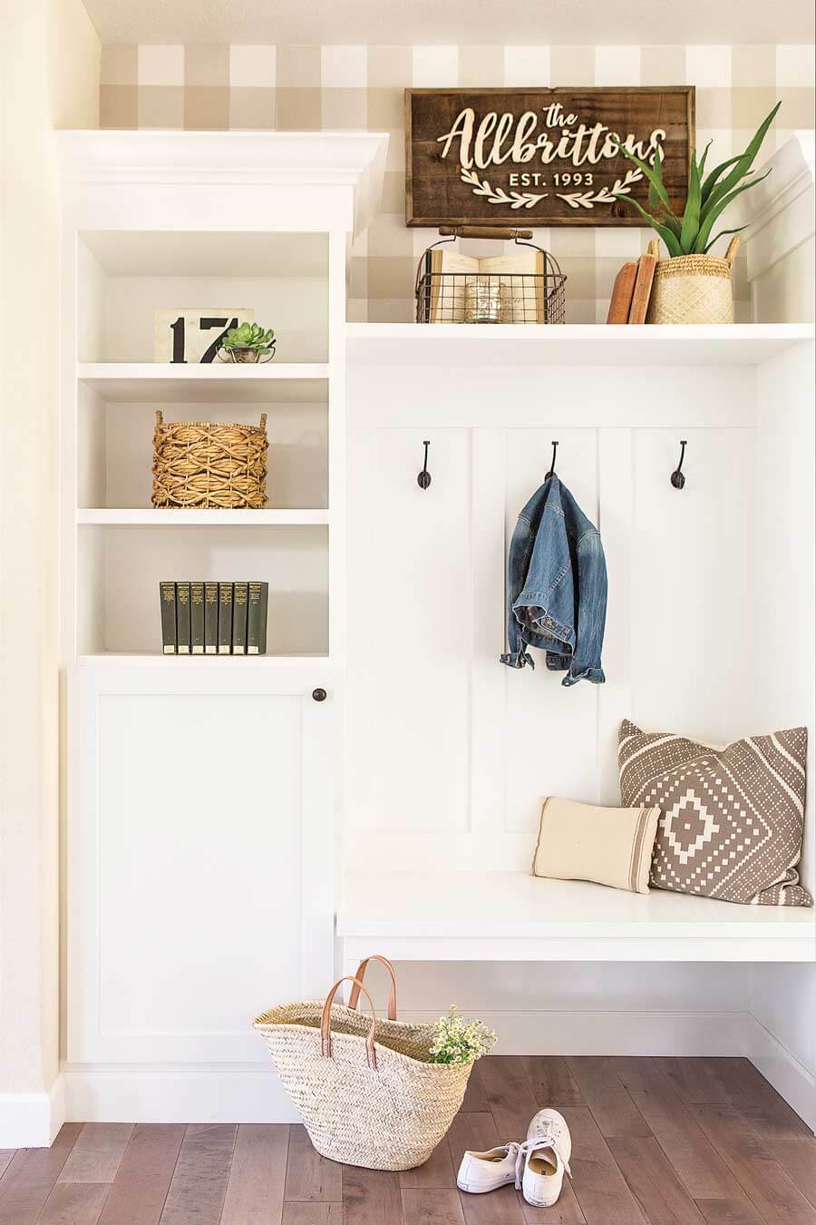 Mudroom with family name sign art, seating bench and lockers.