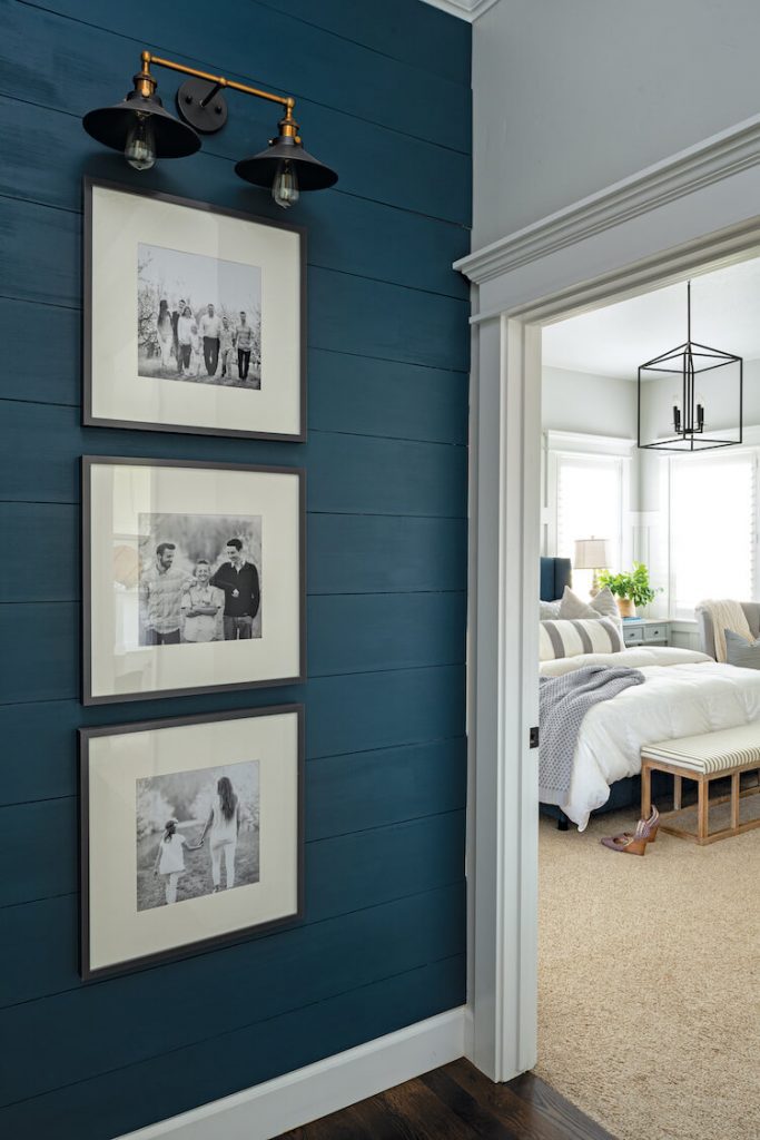 hallway with blue shiplap and framed photographs
