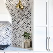 Black and white farmhouse kitchen with herringbone backsplash pattern