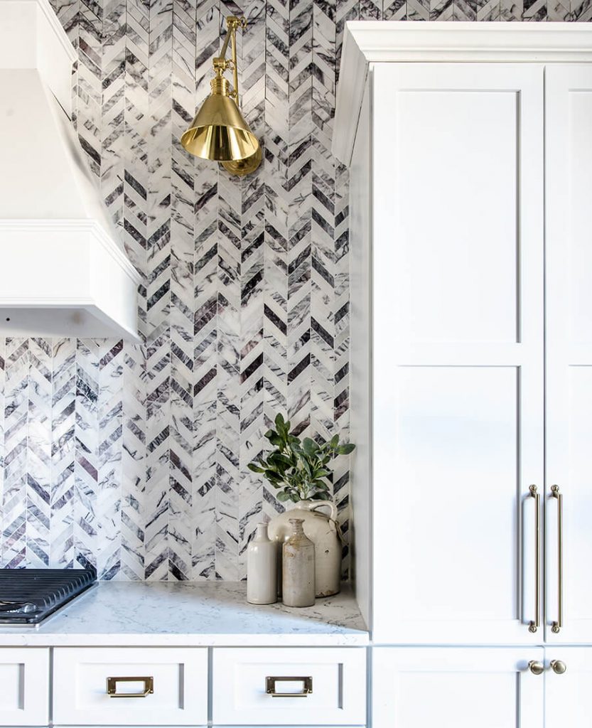 Black and white farmhouse kitchen with herringbone backsplash pattern