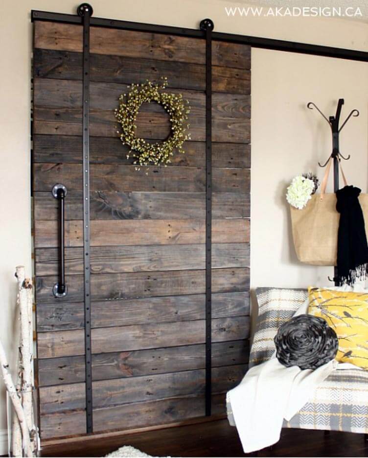 rustic pallet wood sliding door with iron handle and hanging floral wreath
