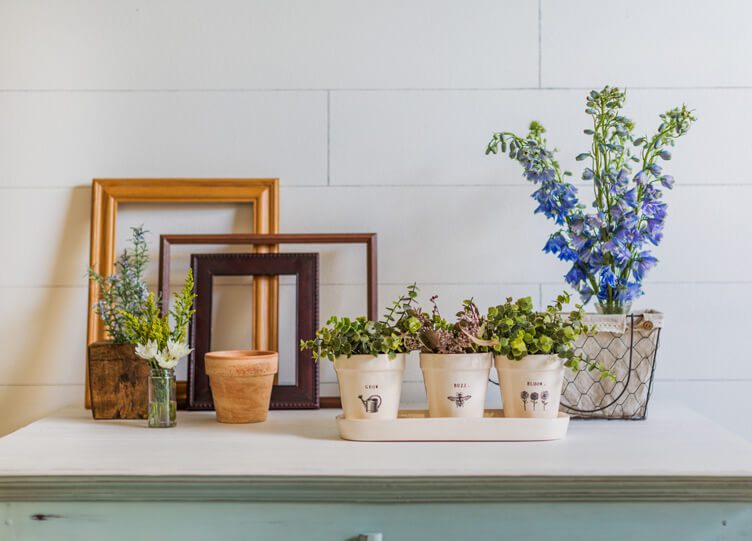 Tabletop styled for spring with vintage frames, fresh flowers and faux flowers