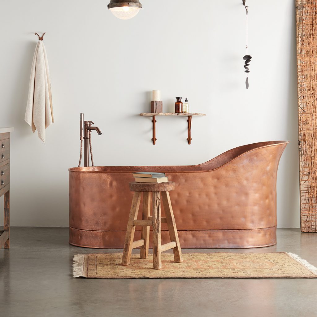 A stunning copper tub completes the rustic theme of the bathroom.