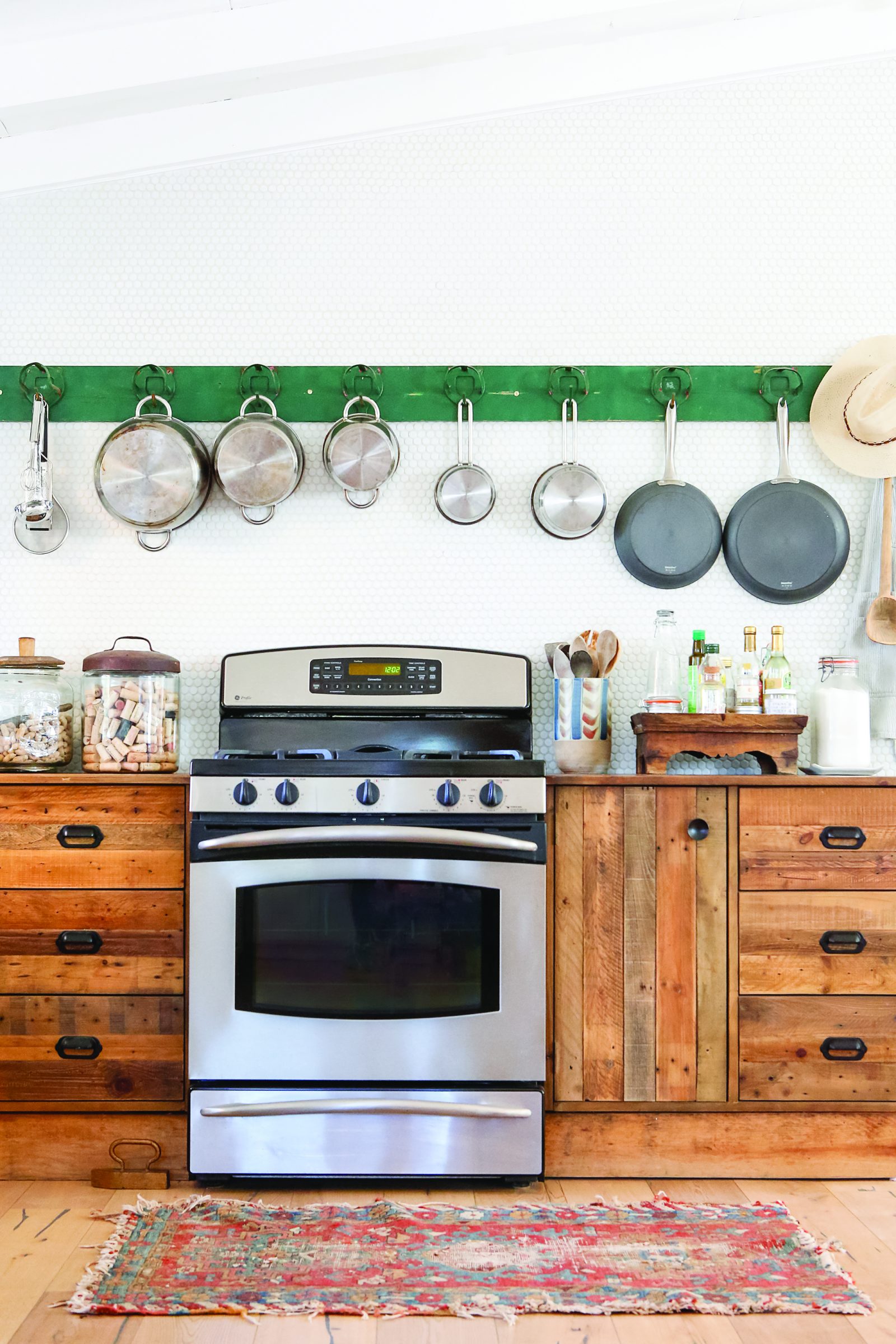 A stove, an American-made appliance, surrounded by several wooden fixtures and a collection of pots hanging above