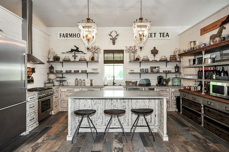 Rustic glam kitchen with white cabinets, stainless steel appliances and counter bar seating. 