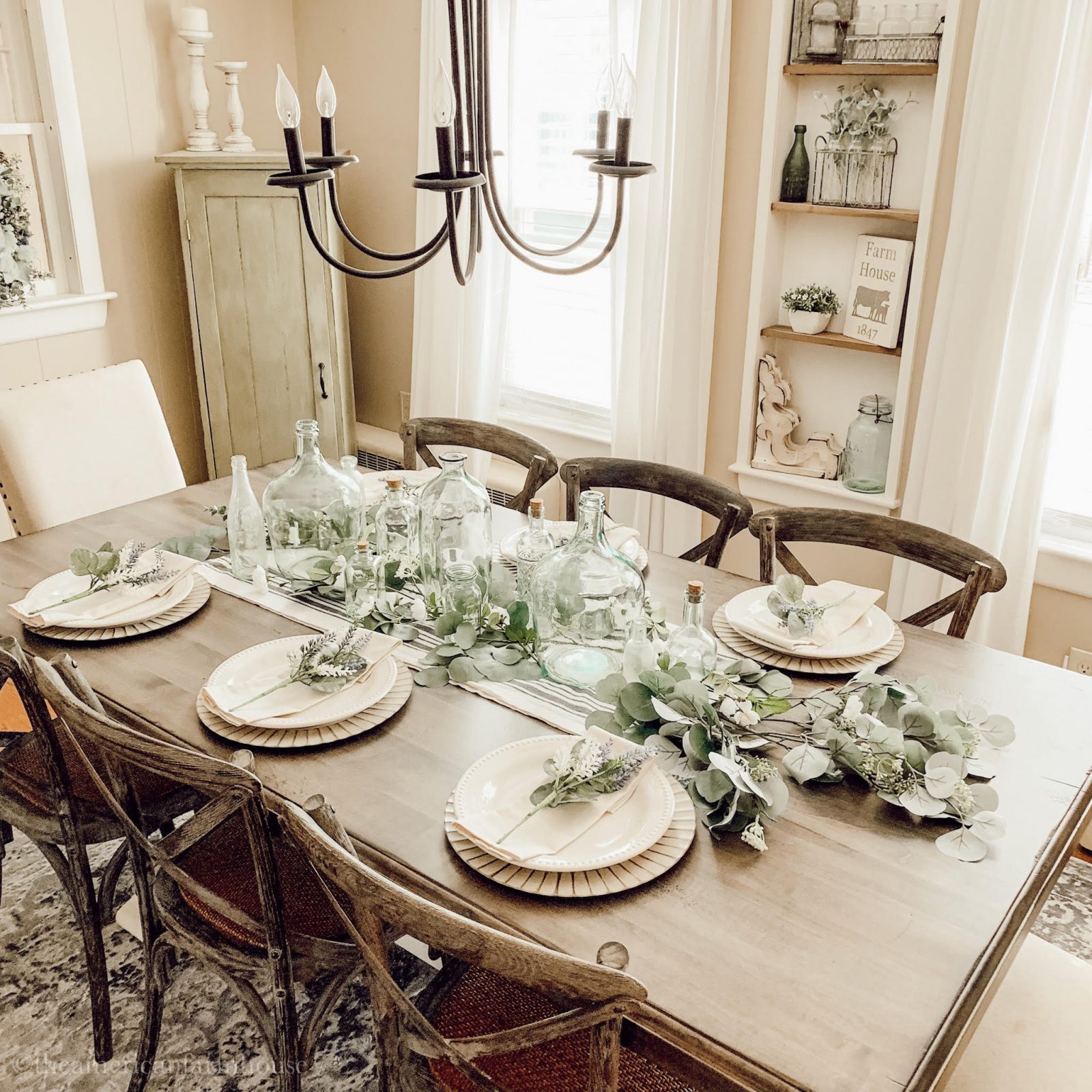 Beautiful upcycled tablescape includes aged bottles and silver dollar eucalyptus leaves