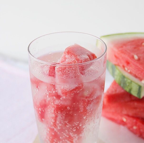 Watermelon ice cubes in a glass of seltzer water