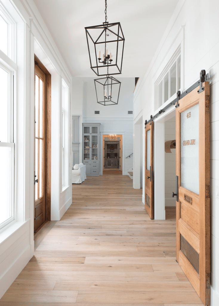 Hallway with sliding doors and industrial chandeliers