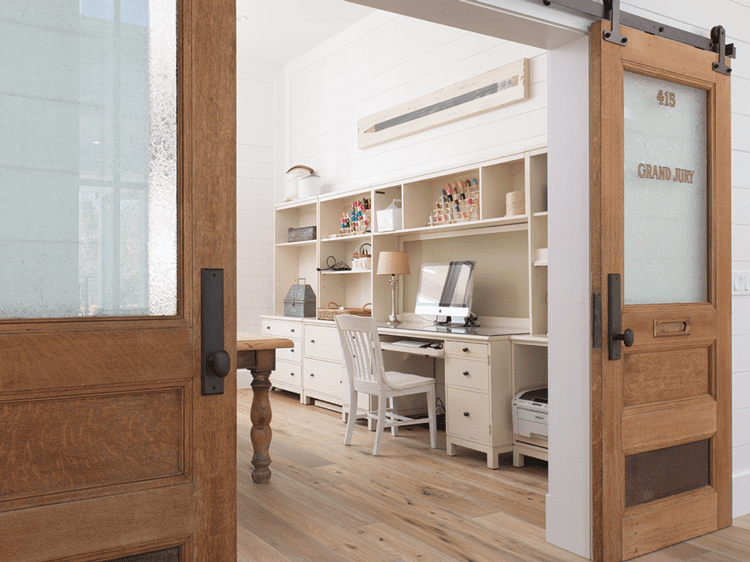 Office space with sliding doors in a wood paneled farmhouse