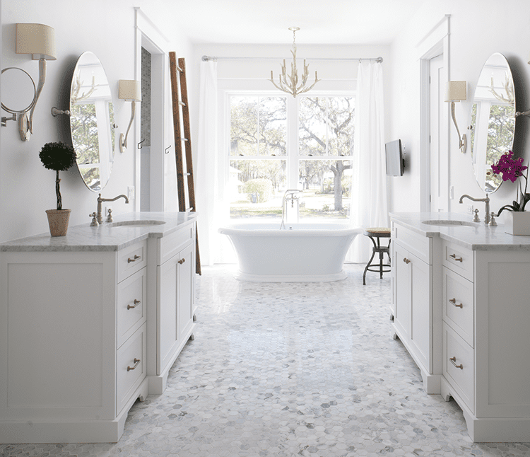 Standalone bathtub in master bathroom with large windows in wood paneled farmhouse