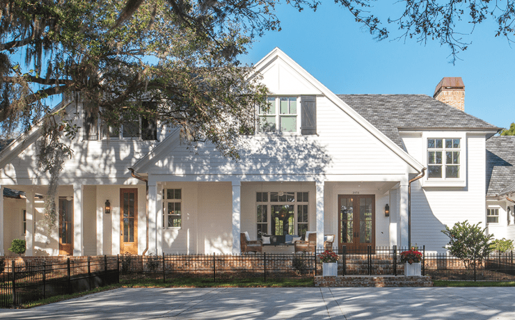 Custom white farmhouse with wood paneling cape cod style