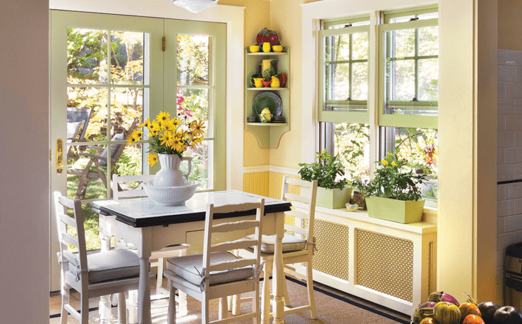 yellow breakfast nook with windows and fresh flowers in historic farmhouse with vintage farmhouse style