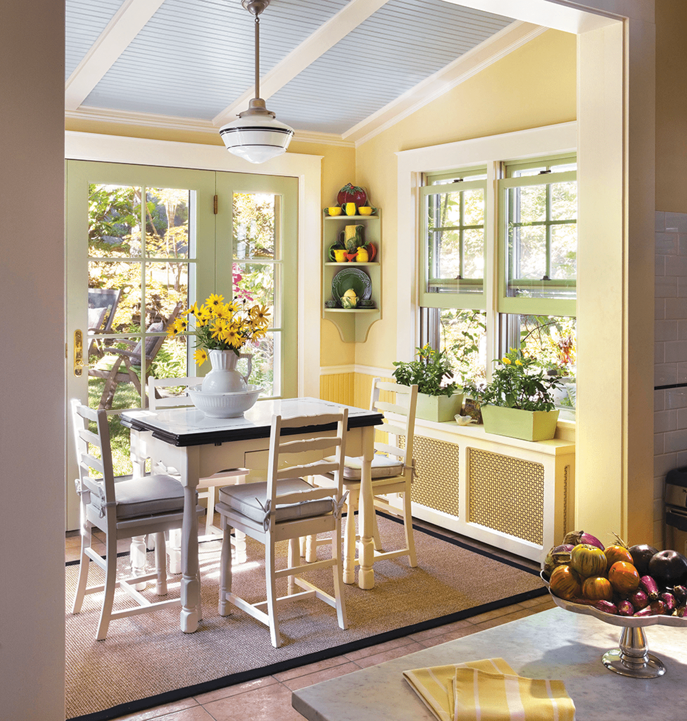 yellow breakfast nook with windows and fresh flowers in historic farmhouse with vintage farmhouse style