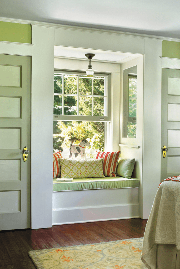 Reading nook by window with green walls in historic farmhouse