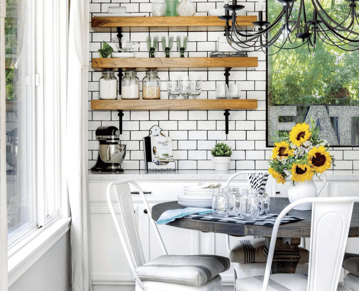 A kitchen with a butcher block counter, subway tile, and a marble countertop in a custom farmhouse