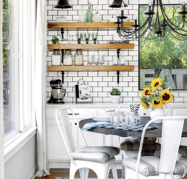 A kitchen with a butcher block counter, subway tile, and a marble countertop in a custom farmhouse