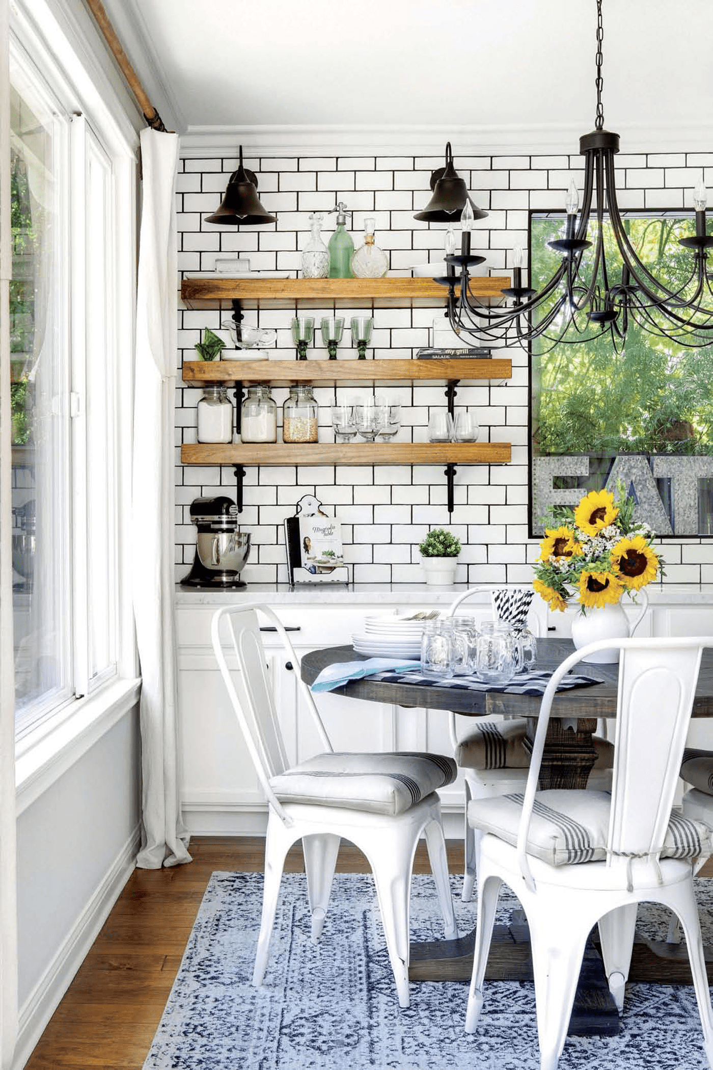 A kitchen with a butcher block counter, subway tile, and a marble countertop in a custom farmhouse