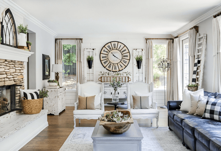 A living room with a stone fireplace and a cozy gray couch in a custom farmhouse.