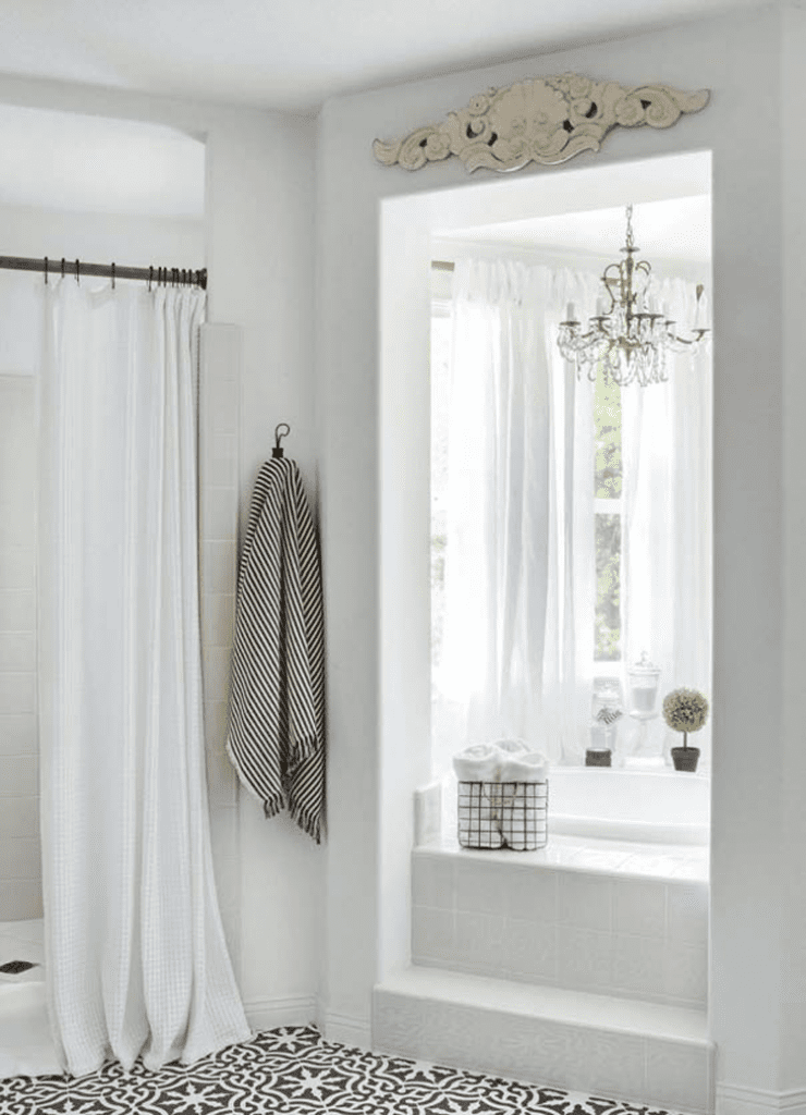 A white master bathroom with a large window and shower in a custom farmhouse