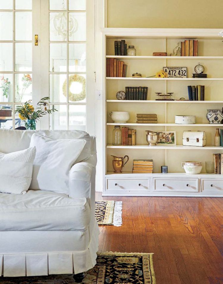 Renovated farmhouse living room with white couch and bookshelves