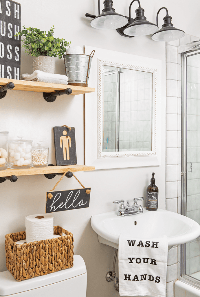 Guest bathroom with pedestal sink, open shelves, and farmhouse details.