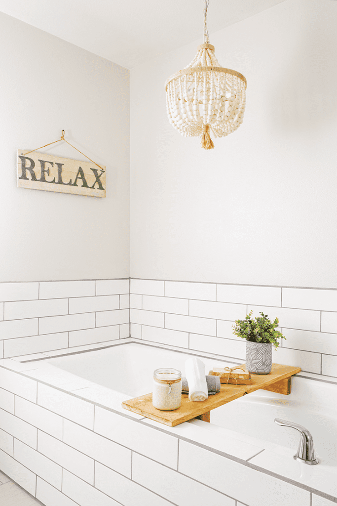 Bathtub with subway tile, shelf, and farmhouse details. 