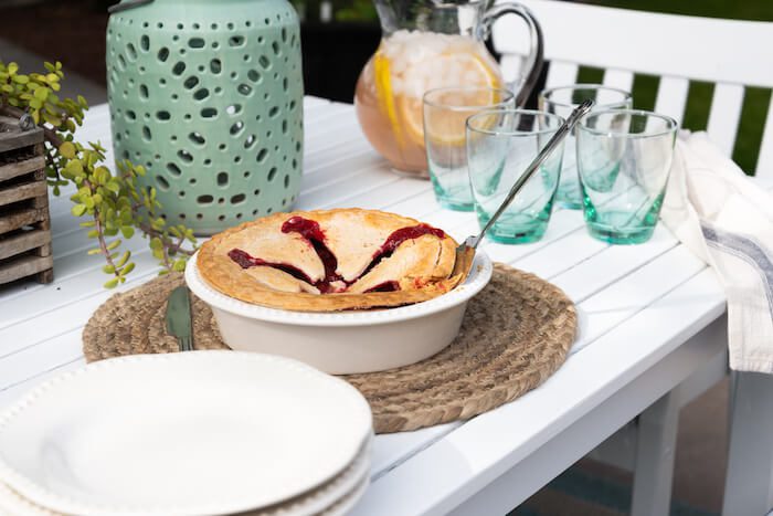 Close up of outdoor dinner party table with cherry pie.