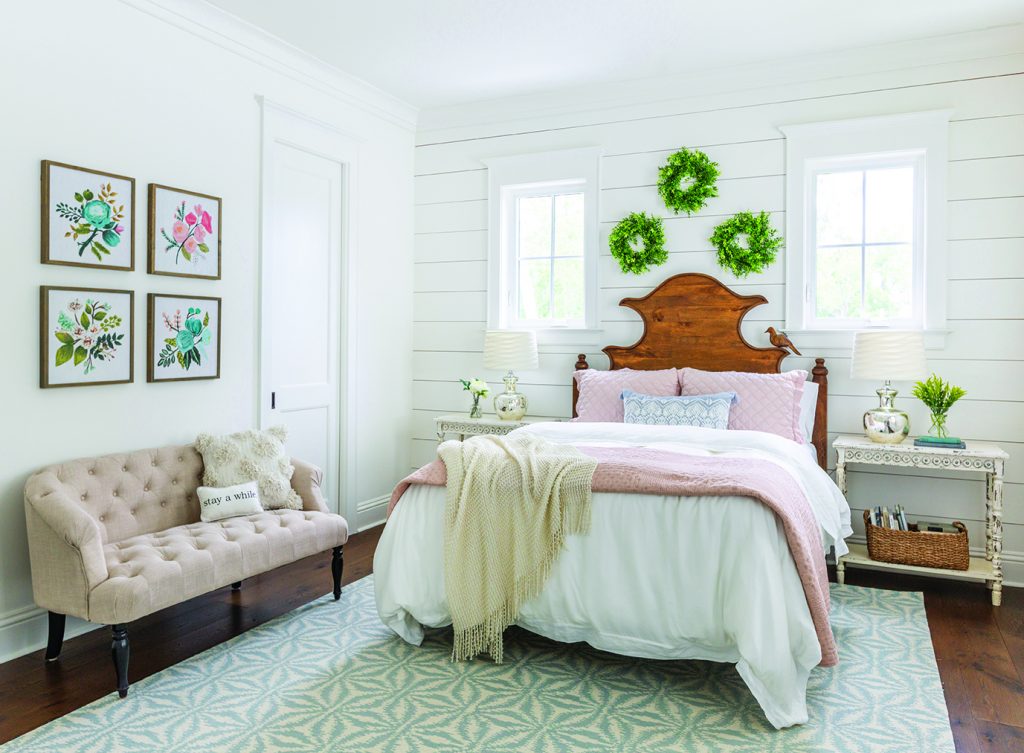 Farmhouse bedroom with shiplap walls and pink bedding