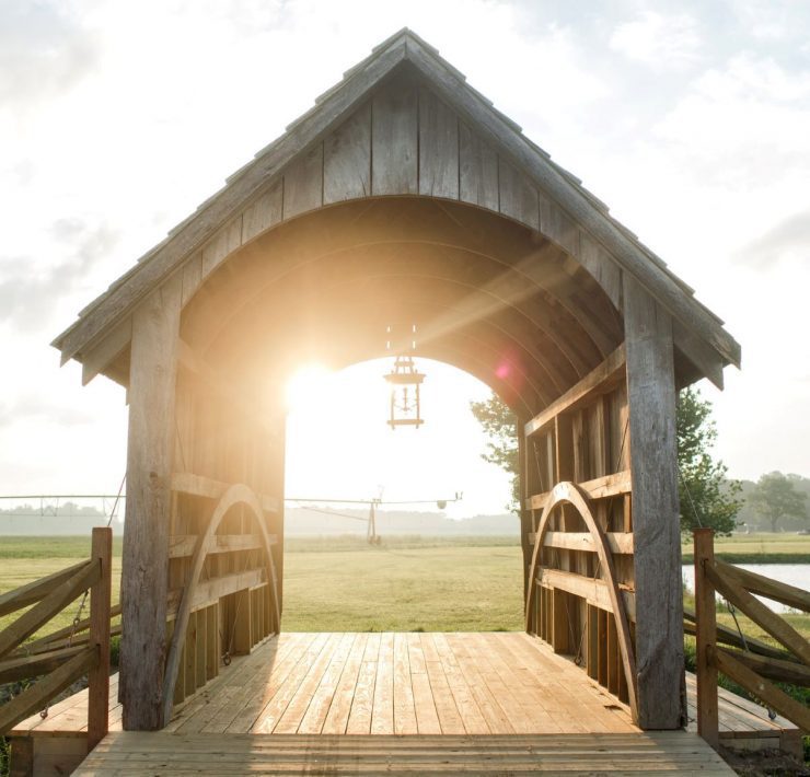 A romantic covered bridge made from aged wood.