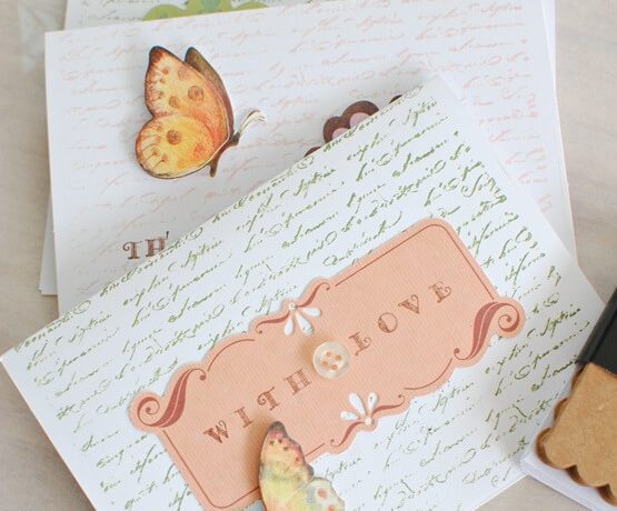 Two cursive-embossed birthday cards, complete with butterflies, buttons, and a paper rustic sign proclaiming “with love”
