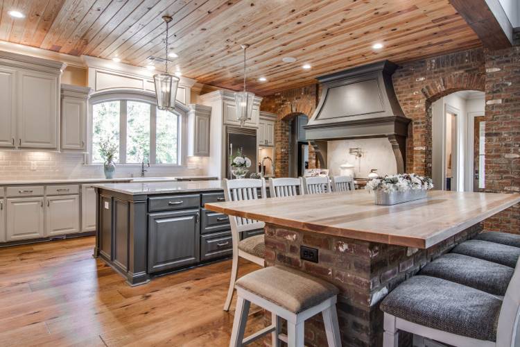 Kitchen with brick island and arched brick wall.