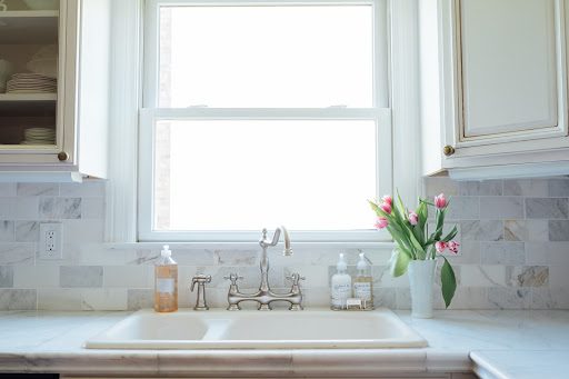 All-white kitchen with marble countertops and backsplash