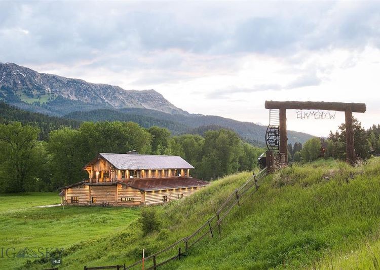 Distant view of Montana ranch with entrance and mountain