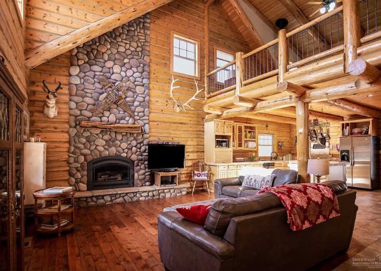 Oregon ranch living room with fireplace, wood features, and animal busts.