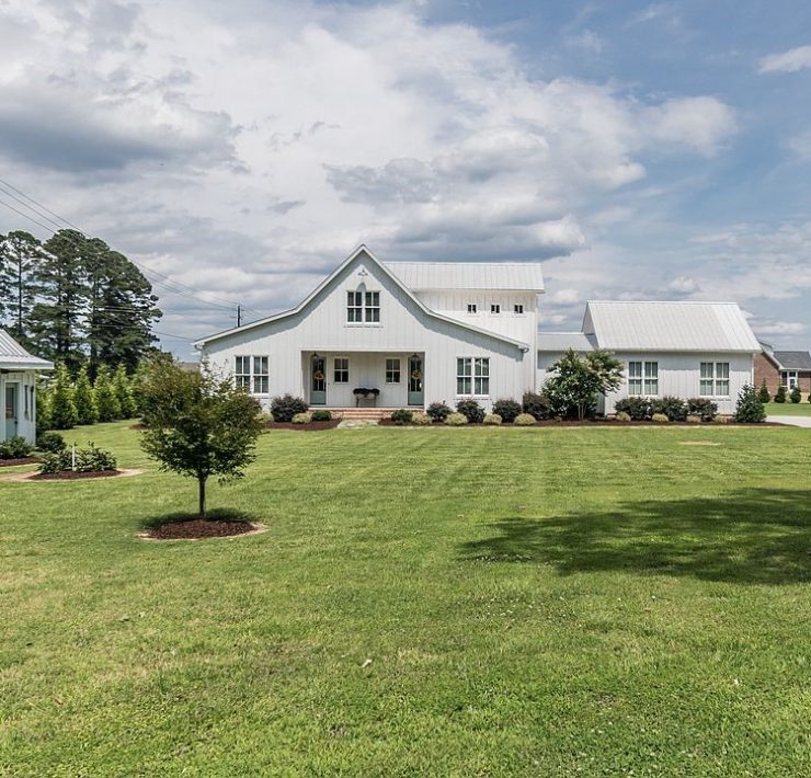 The front view of a white farmhouse shaped like a classic barn.