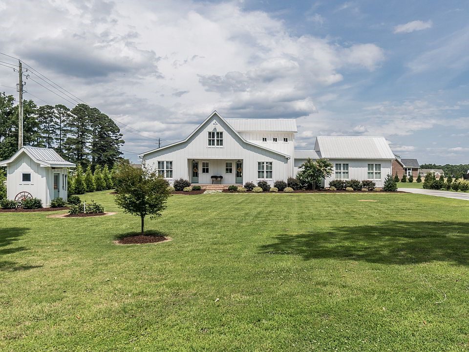 The front view of a white farmhouse shaped like a classic barn.