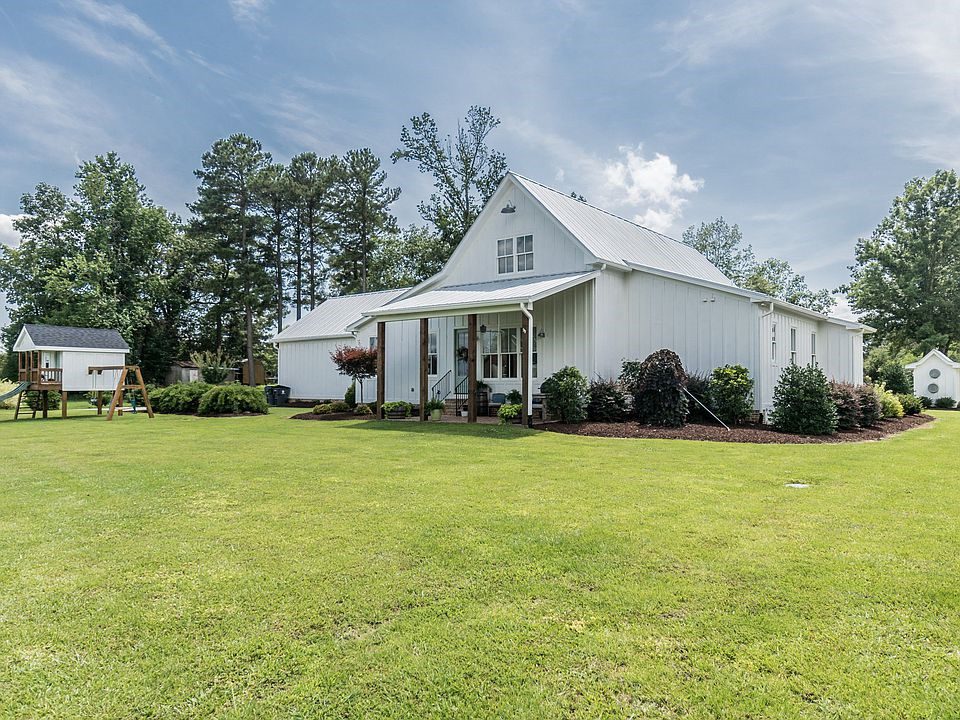 The back view of the home, with it's wood columns, matches the child's swing set.