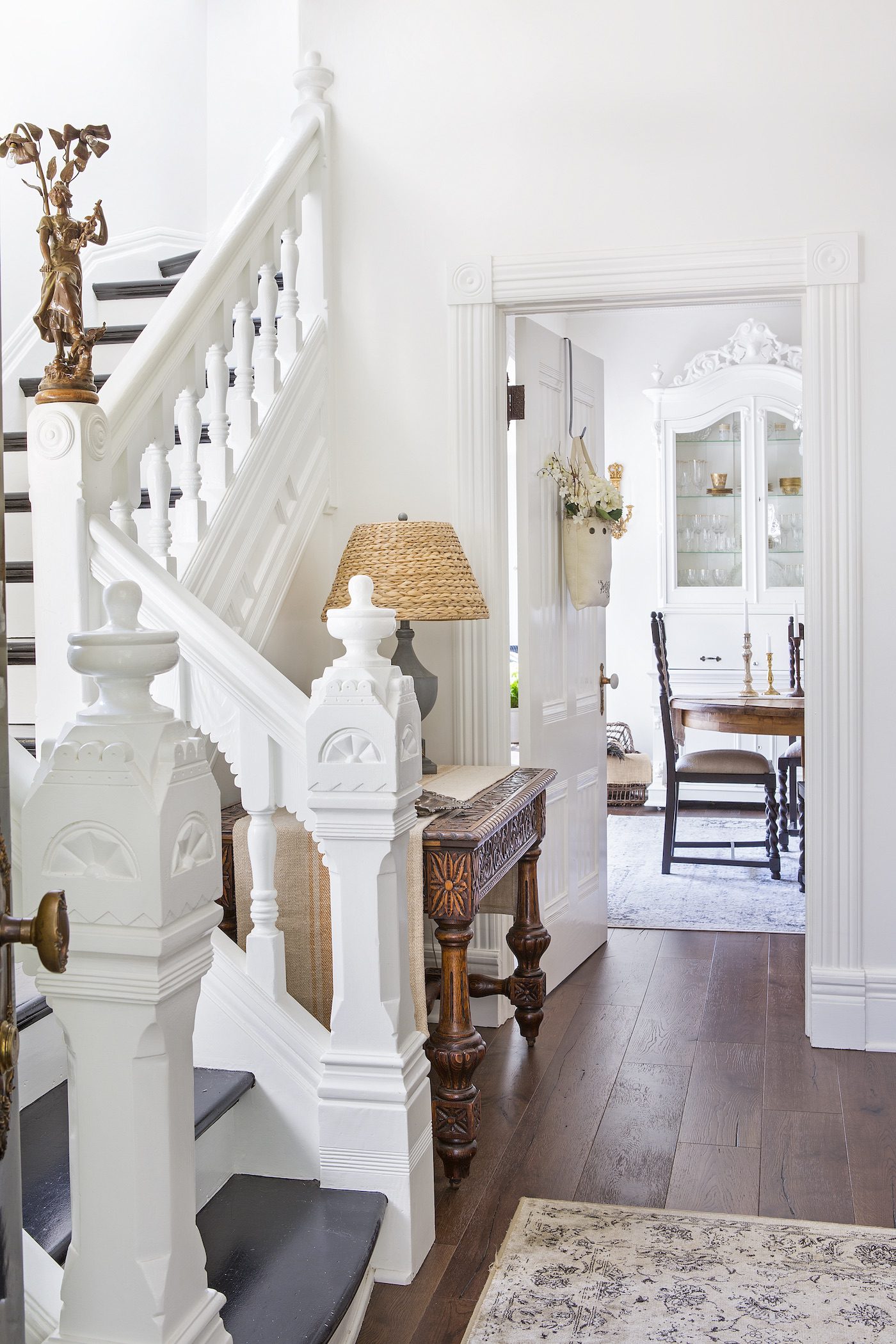 Entryway and staircase with white decor and hardwood floors in french farmhouse style