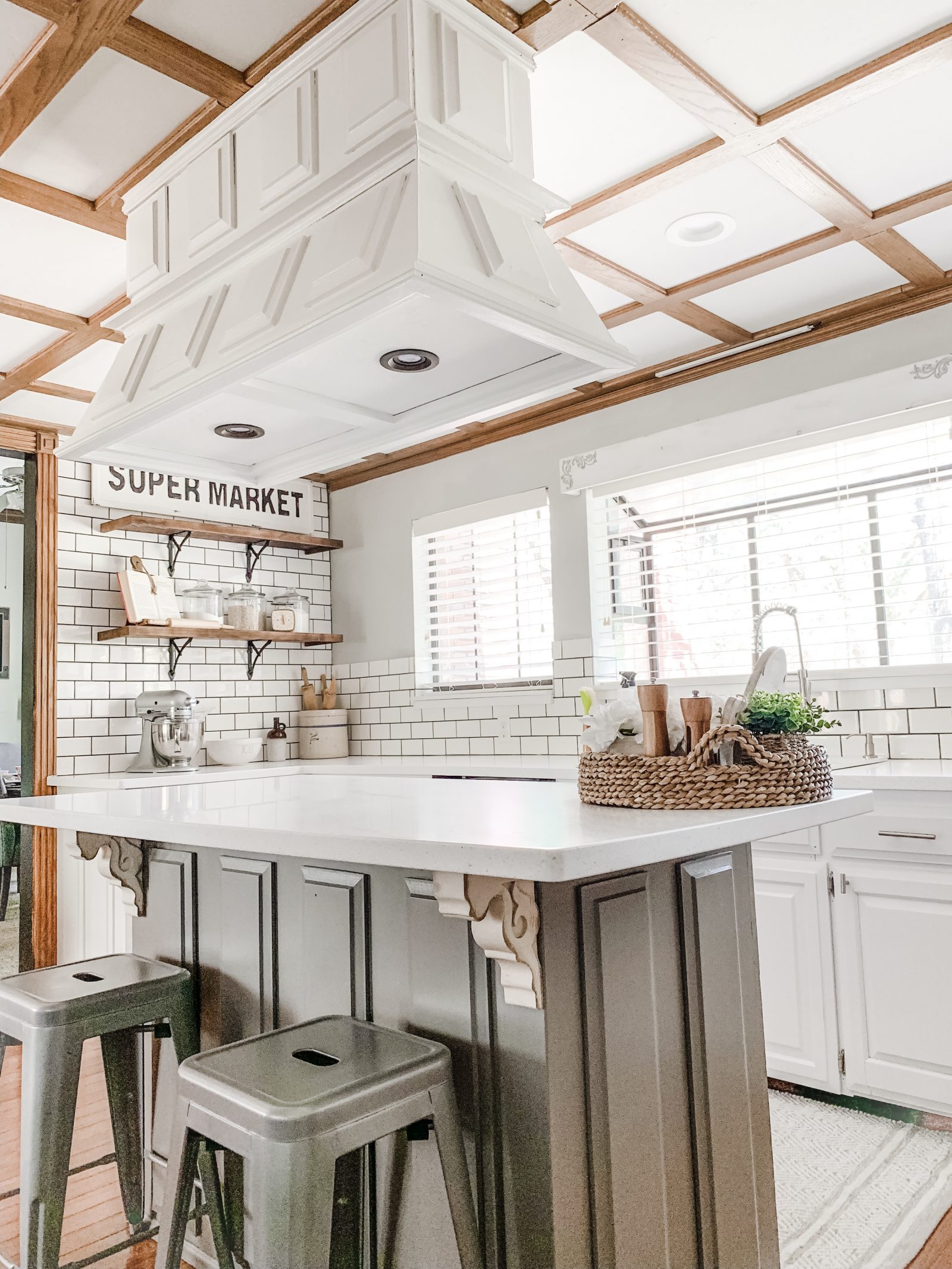 The kitchen is a lustrous white color with added details of shiny silver and gray colors.