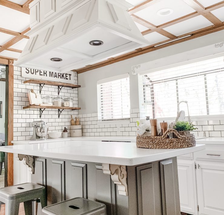 The kitchen is a lustrous white color with added details of shiny silver and gray colors.