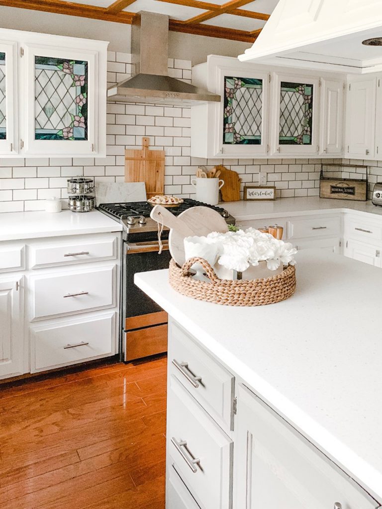 This kitchen has all white cabinetry and a gray island that renders a contrast