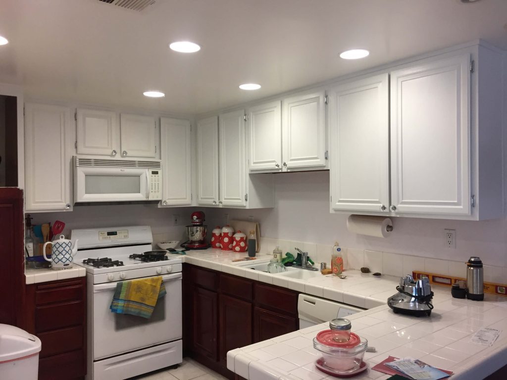 Finished white upper cabinets with old varnish on the lower cabinets