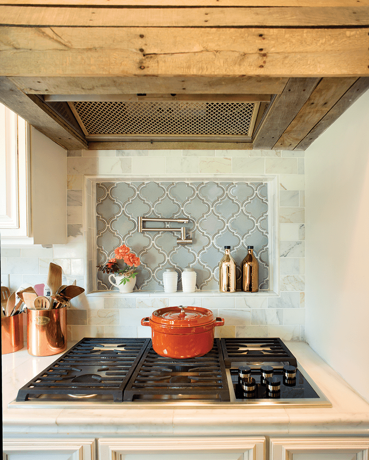 Wood covered kitchen hood with red pot on range mid century farmhouse. This is a deep clean area.