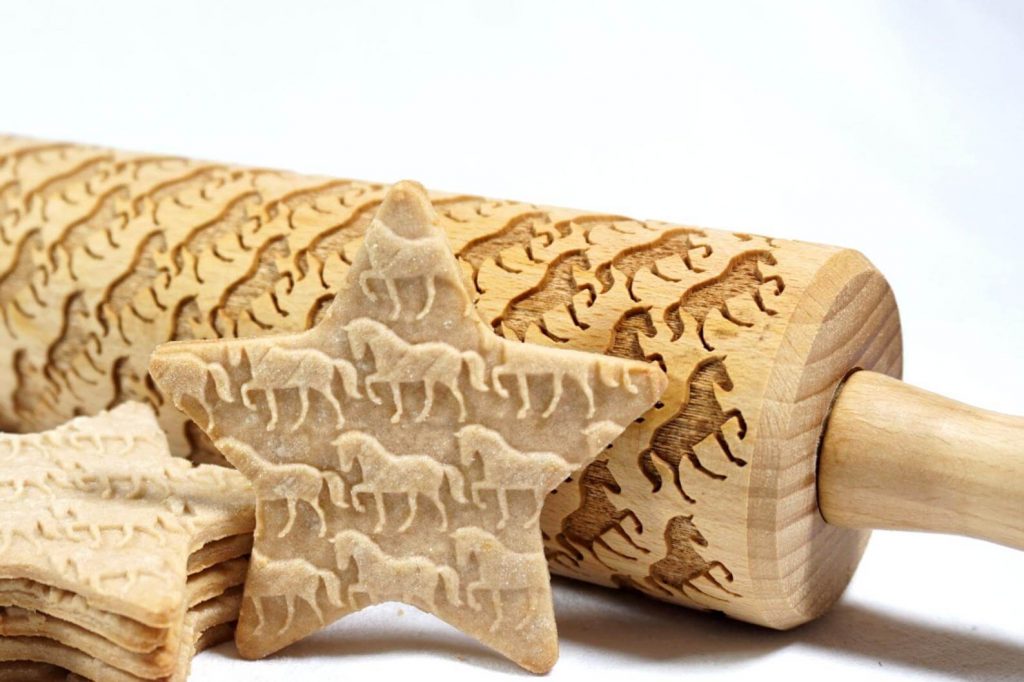 A wooden rolling pin embossed with miniature horses