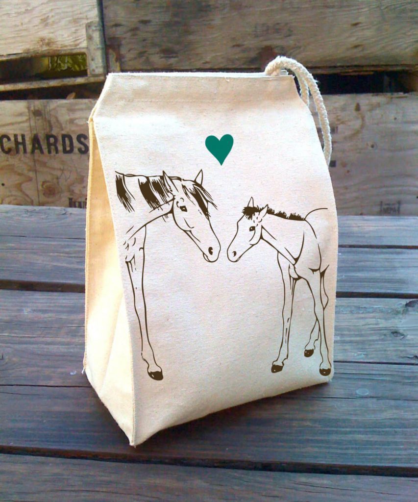 A canvas lunch bag illustrating two horses and a blue heart in between them